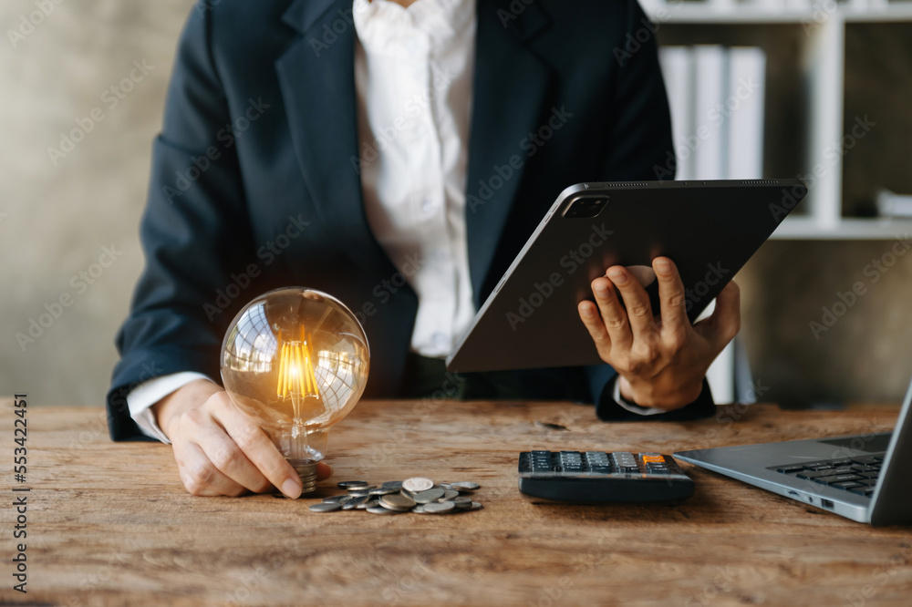 Poster business man hand holding lightbulb with using smartphone and calculator to calculate and money stac