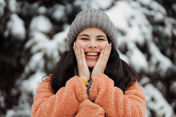 Happy pretty young woman using a sking protection cream in winter
