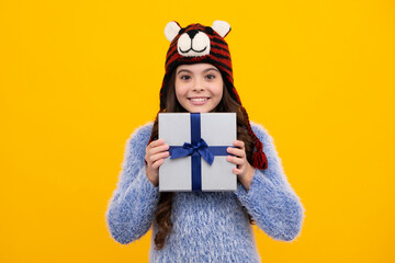 Teenager child in winter wear holding gift boxes celebrating happy New Year or Christmas. Winter kids holiday. Happy teenager, positive and smiling emotions of teen girl.