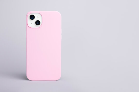 high quality starlight color iPhone 14 Plus in pink case isolated on gray background back view, Banner with place for text on the right, smartphone cover mock up