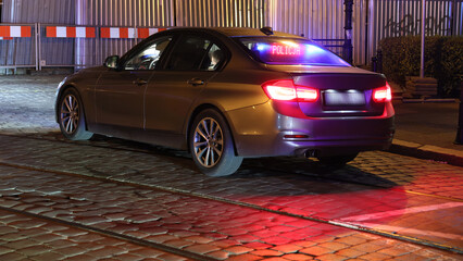 Nieoznakowany samochód policyjny polskiej policji w wieczornej akcji na drodze.