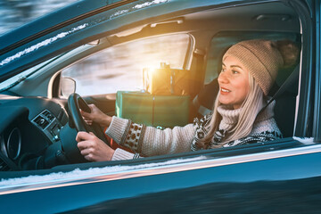 Woman Giving Gifts. Female is holding presents and delivering them on her car to Home. Holidays...