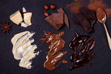 three types of solid and melted chocolate, milk, white and dark. View from above