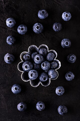 aluminum mold for cakes with fresh blueberries on a dark textured background. view from above.