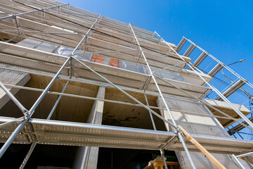 Shot from below on the unfinished housing edifice with scaffolding, work in progress