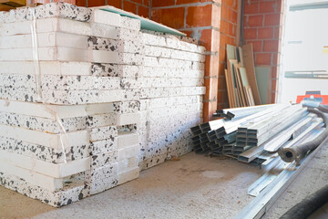 Crowd of thermal isolation material of Styrofoam and aluminum profiles for partition walls stacked on floor of storage, ready for mounting