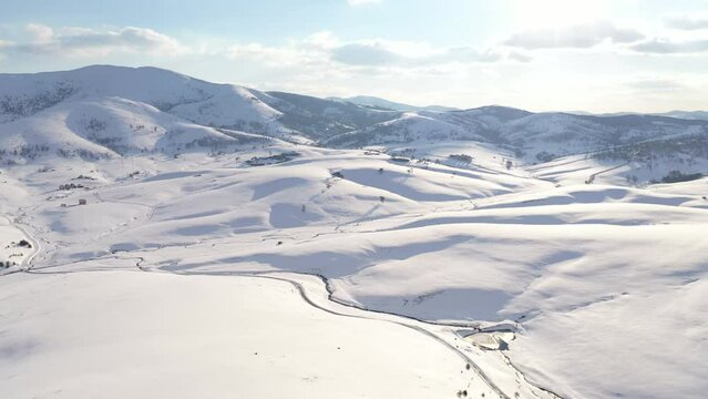 Aerial shot of snow-capped mountain hill in winter at Zlatibor, Serbia from drone pov.