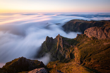 Beautiful sunrise over the sea of clouds. View of the rocks and peaks of Madeira Island, Portugal
