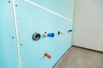 Plasterboard wall with installations for water and electricity of unfinished kitchen