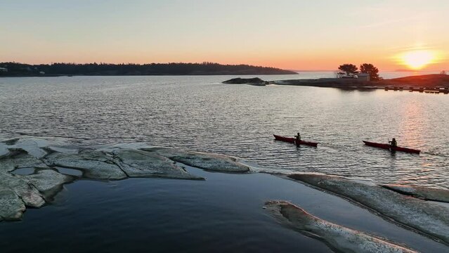 Aerial view of people kayaking in the archipelago, during sunset - circling, drone shot