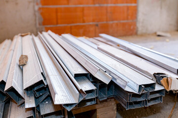 Heap of aluminum profiles for partition walls stacked on pallet, ready for mounting