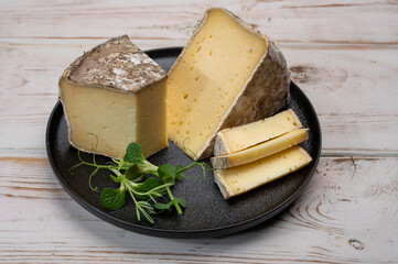 Pieces of cheese tomme de montagne or tomme de savoie made from cow milk in French Alps
