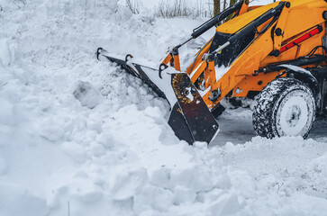 Tractor bucket unfolds snow outside
