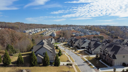 Fototapeta na wymiar Aerial view rare beautiful cloud formation over subdivision sprawl with row of two story houses lead to horizontal suburbs Atlanta, Georgia, USA
