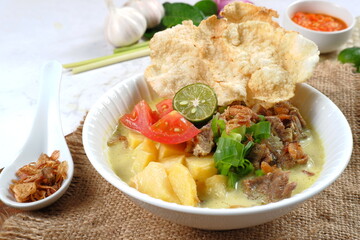 Soto Betawi. Traditional beef and offal soup from Betawi, Jakarta. The soup has been preplated in a...