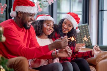 Christmas Celebration. Happy family mother, father and daughter celebrate Christmas and new year with sparklers celebrating Christmas at home.