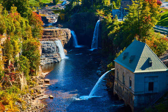 Hydroelectric power plant in canyon surrounded by multiple large waterfalls