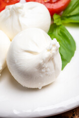 Eating of fresh handmade soft Italian cheese from Puglia, white balls of burrata or burratina cheese made from mozzarella and cream filling