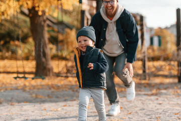 Obraz premium Playing, having fun together. Father and young son is together outdoors at daytime