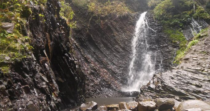 Mystery waterfall with reversal of time and temporal warp. Reverse Time Slow Motion video of beautiful waterfall in the mountains. Cinema 4K 60fps Slow Motion video