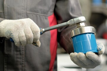 Maintenance of a passenger car.Replacement of the oil filter. An auto mechanic holds an oil filter...