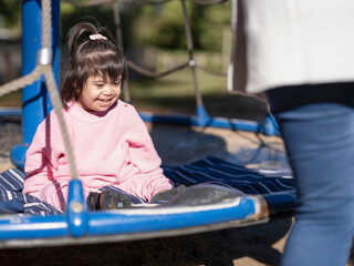 Smiling girl with Down syndrome on playground - obrazy, fototapety, plakaty