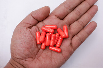 Pills in hand and on white background