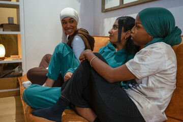 Smiling women wearing hijabs talking at home