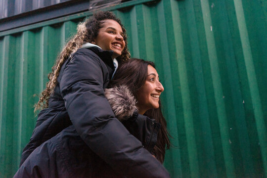 Woman giving piggyback ride to friend
