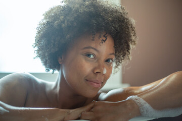 Portrait of woman leaning on edge of bathtub