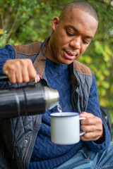 Man pouring warm drink from a insulated flask
