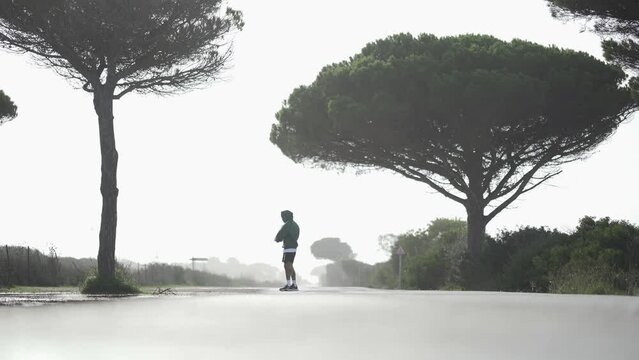 Chico joven en calzonas calentando para salir a correr en mitad de un camino con niebla de fondo
