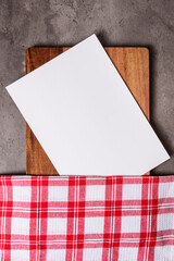 white paper and checkered cloth on wood on dark marble background