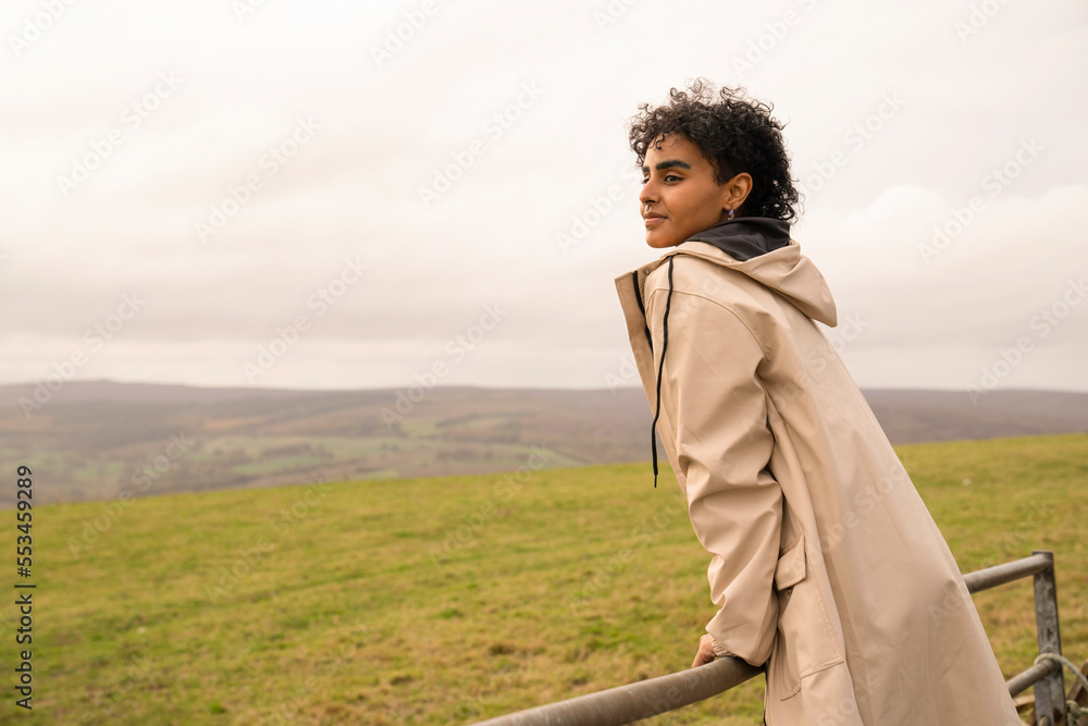 Wall mural Young female hiker looking at landscape