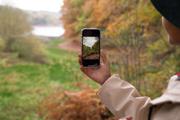Woman photographing landscape while hiking