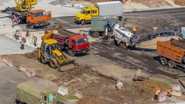 Aerial view of large road construction site with several industrial machines timelapse. Earthmoving equipment and asphalt milling machine