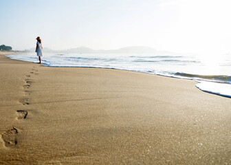 Young woman walking on the beach.
