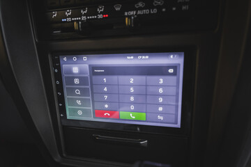 Screen on the center console of the car with telephone dialing.
