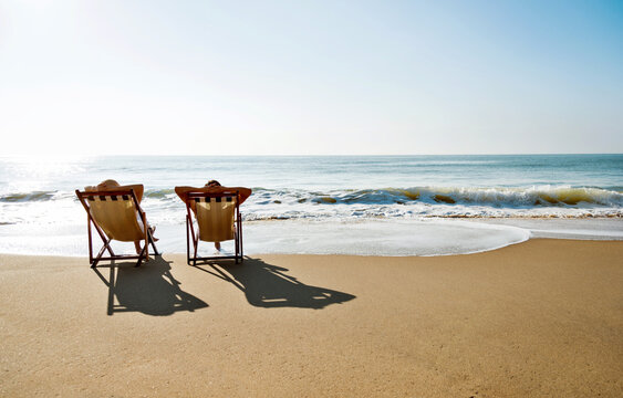 Couple sunbathing on a beach chair.
