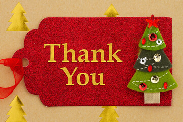 Thank You message on red holiday gift tag with a Christmas tree