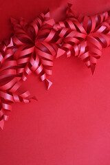Festive red background for Christmas with red snowflake made of paper on selective focus with copy space