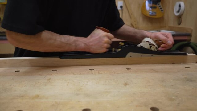 Flattening and smoothing piece of maple wood using a hand plane.