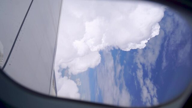 Looking out from Airplane window on beautiful clouds and blue sky day