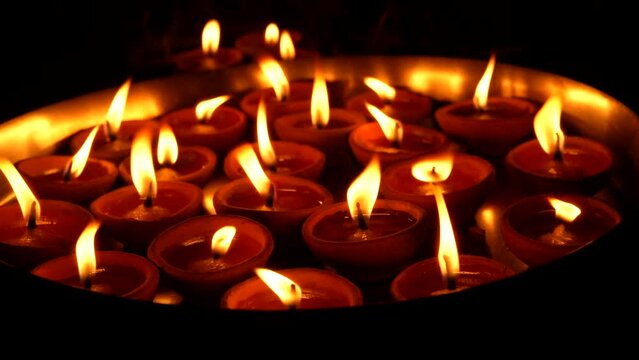 A female hand holding oil lamps plate in hand during deepavali festival. Diya or traditional clay lamps on Diwali festival. Indian Hindu religious ritual tradition at Diwali. 4K Slow Motion.