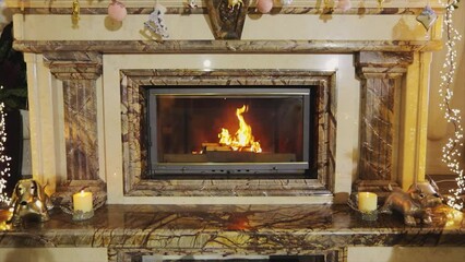 Firewood is burning in the fireplace. New Year's interior with a fireplace. Fire in the fireplace. Beautiful fireplace with wood
