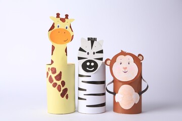 Toy monkey, giraffe and zebra made from toilet paper hubs on white background. Children's handmade...