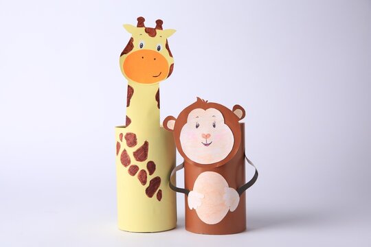 Toy monkey and giraffe made from toilet paper hubs on white background. Children's handmade ideas