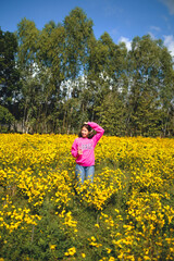 Fototapeta premium A woman wearing a pink dress is taking a walk in a yellow flower garden called Chrysanthemum during the day. At Pak Thong Chai District, Thailand 4-12-2022