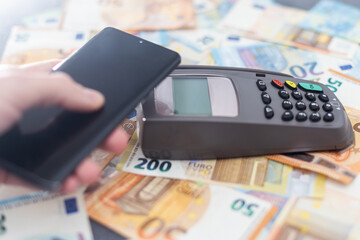 Banking terminal on euro banknotes background close up