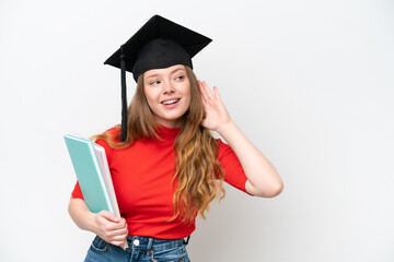 Young university graduate woman isolated on white background listening to something by putting hand on the ear